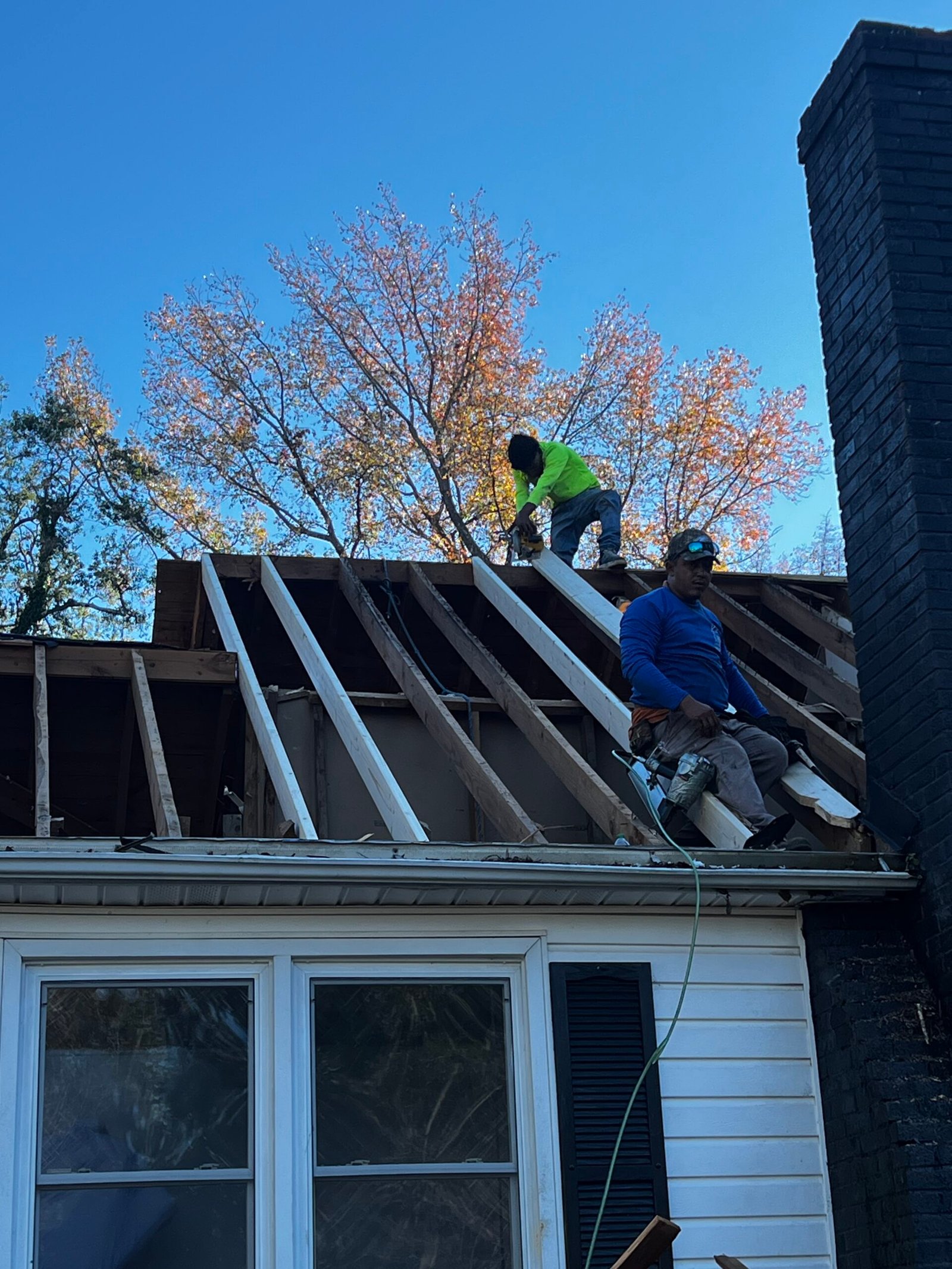 Roof rafter construction with workers - IAC Construction