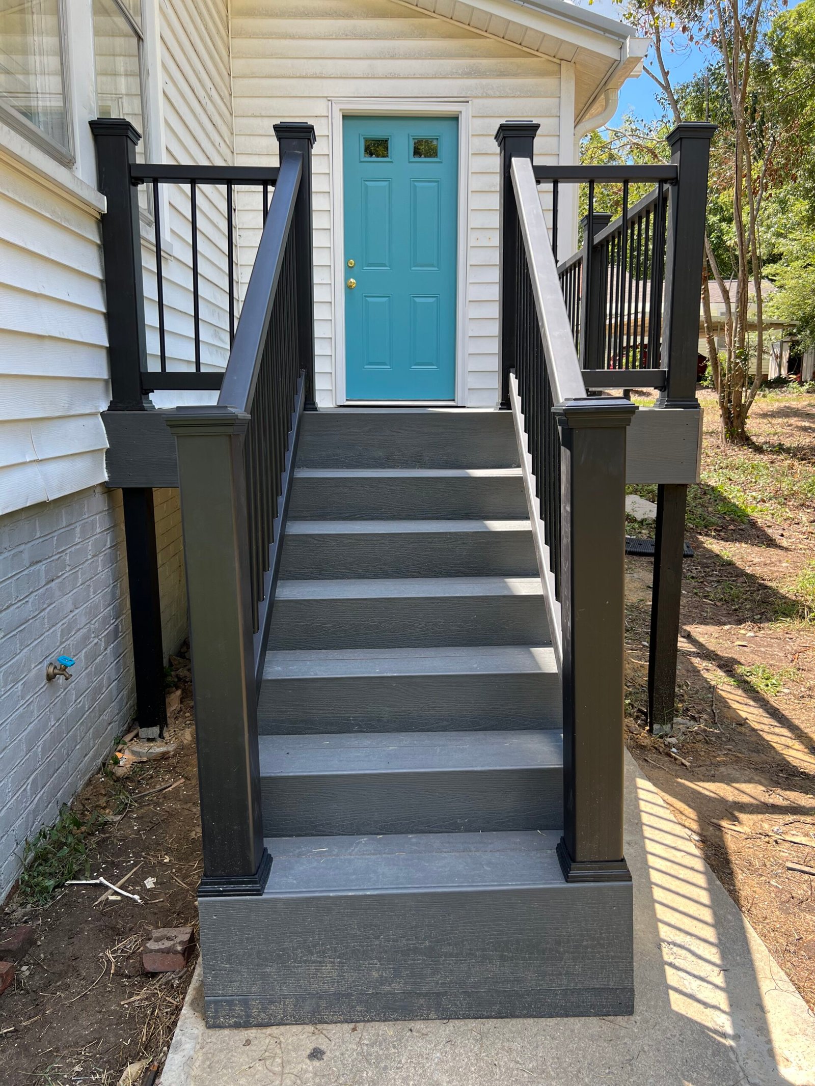IAC Construction rear exit wooden deck stairs and black railings
